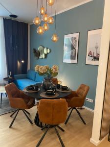 uma sala de estar com uma mesa com cadeiras e um sofá azul em Pure Berlin Apartments - Luxury at Pure Living in City Center em Berlim