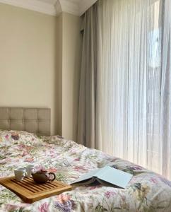 a tray with two cups and a book on a bed at Halic Apart Hotel in Yalova