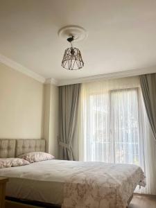 a bedroom with a bed with a chandelier and a window at Halic Apart Hotel in Yalova