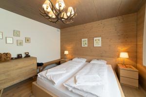 Schlafzimmer mit einem großen Bett und Holzwänden in der Unterkunft Primula in Wildhaus