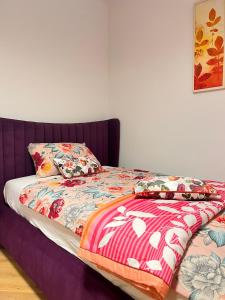 ein Bett mit einer bunten Bettdecke und Kissen darauf in der Unterkunft Villa Vida, Medulin - Bazen i jacuzzi in Medulin