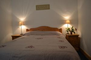 a bedroom with a bed and two lamps on two tables at Les Granges 22 in Aime