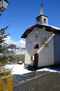 una pequeña capilla blanca con un campanario en una montaña en Les Granges 22, en Montalbert