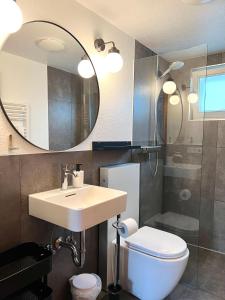 a bathroom with a sink and a toilet and a mirror at THE KREIDESEE 47 - Hemmoor in Hemmoor