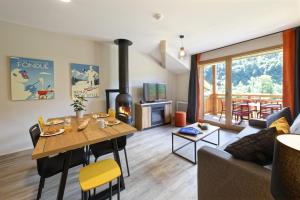 a living room with a table and a fireplace at Résidence Club MMV Samoens in Samoëns