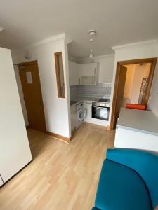 a living room with a blue couch and a kitchen at Stylish & compact city center studio apartment in Norwich