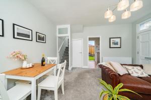 sala de estar con mesa y sofá en Robins Nest Cottage, en Blairgowrie