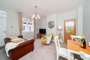 sala de estar con sofá y mesa en Robins Nest Cottage en Blairgowrie