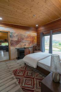 1 dormitorio con cama, escritorio y ventana en SaffronStays Paradise Pines, Dehradun - cliff villa with valley & forest views en Dehradun