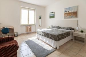 una camera con un letto e una sedia e una finestra di [House of Poet] Wide Apartment in the City Center ad Asti
