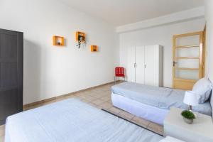una camera con due letti e una sedia rossa di [House of Poet] Wide Apartment in the City Center ad Asti