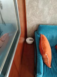 a blue bed with a pillow next to a window at MILAN SOUTH GATE APARTMENT in Milan