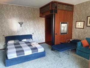 1 dormitorio con 1 cama azul y 1 silla azul en MILAN SOUTH GATE APARTMENT en Milán