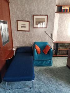 a living room with a blue couch with orange pillows at MILAN SOUTH GATE APARTMENT in Milan