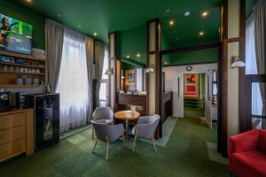 Habitación con paredes verdes, mesa y sillas. en Hotel Zelená Marina en Vrchlabí