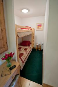 モンタルベールにあるChalet de Montalbert 22Bのベッドルーム1室(二段ベッド2組、緑のカーペット付)
