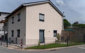 a white house with a fence in front of it at Ferienwohnung mit Salzachblick in Laufen