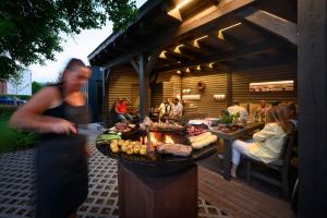 kobieta stojąca przed grillem z jedzeniem w obiekcie Hotel Zelená Marina w Vrchlabi