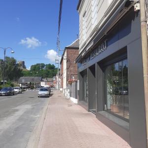 an empty street with a building and a store at Hôtel de Guise SARL in Guise