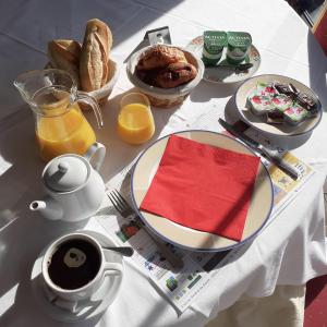 una mesa con un plato de comida y una taza de café en Hôtel de Guise SARL, en Guise