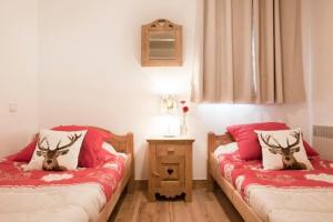 two beds in a room with red and white sheets at Les Granges 14 for 10 people in Montalbert
