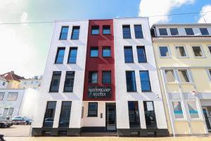 ein hohes Gebäude mit einem roten Schild darauf in der Unterkunft Haverkamp Suites in Bremerhaven