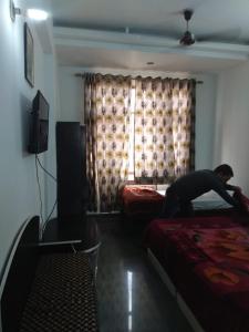 un hombre saltando en una cama en una habitación de hotel en Hotel Green Hills Residency By WB Inn en Kulu