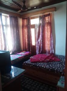 Zimmer mit 2 Betten und einem Fenster mit Vorhängen in der Unterkunft Hotel Green Hills Residency By WB Inn in Kulu