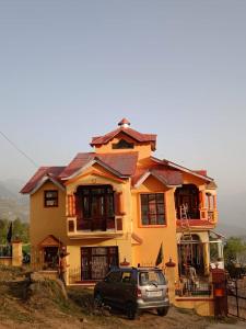 une maison avec une voiture garée devant elle dans l'établissement Hotel Green Hills Residency By WB Inn, à Kulu