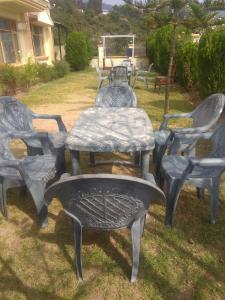 a group of chairs and a table in a yard at Hotel Green Hills Residency By WB Inn in Kulu
