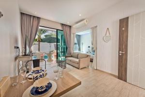 ジョムティエンビーチにあるトロピカーナ プール ヴィラのテーブルとリビングルームのあるリビングルーム