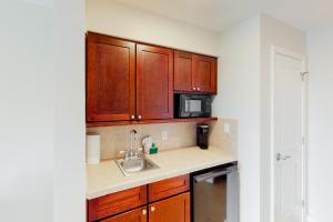 a kitchen with wooden cabinets and a sink and a microwave at Sandestin Luau 6525 in Destin