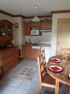 eine Küche mit einem Holztisch mit roten Platten darauf in der Unterkunft Le Chalet de Montalbert 25C in Montalbert