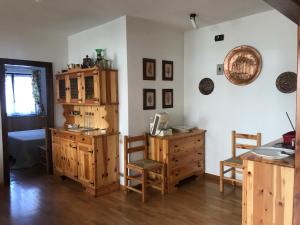 オヴィンドリにあるBig apartment Ovindoliの木製のキャビネット、テーブルと椅子が備わる客室です。