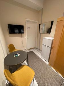 a room with a table and chairs and a refrigerator at Kuukkeli Ivalo Airport Inn in Ivalo