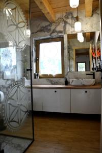 La salle de bains est pourvue d'une baignoire, d'un lavabo et d'un miroir. dans l'établissement Chata Glamour, à Sopotnia Mała
