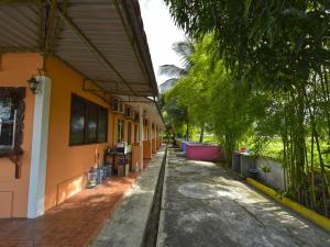 a house with a walkway next to a building at OYO 90561 Awan Biru Motel in Pantai Cenang