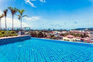 una piscina en la parte superior de un edificio con palmeras en Superbe Studio avec Salle De Bain Privee Kata Beach Phuket Phuket, en Kata Beach