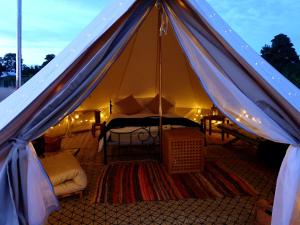 Zelt mit einem Bett und einem Tisch in der Unterkunft Luxury 5m bell tent with log burner near Whitby in Saltburn-by-the-Sea