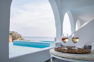 dois copos de vinho sentados numa mesa numa sala em Vento Isolano suites em Cárpatos