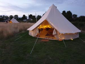 a large white tent with lights in a field at 6 Guests - Bell Tent - Wood Stove - Views in Liverton