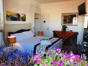 a bedroom with a bed and a table with flowers at Sogna Venezia in Mestre