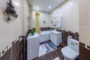 y baño con aseo, lavabo y espejo. en Просторная квартира в жк Науаи около ТРЦ МЕГА, en Almaty