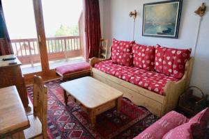 sala de estar con sofá rojo y mesa en Chalet de Montalbert 32C 5-7 pers en Aime La Plagne