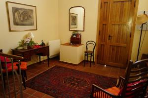 a living room with a table and a desk and a door at Casa Antonio in Alájar