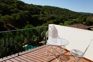 un patio con 2 sillas y una mesa en el balcón en Casa Antonio, en Alájar