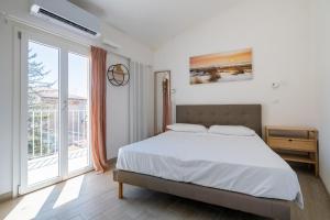 a bedroom with a bed and a large window at Appartamento vicino all'Orto Botanico by Wonderful Italy in Bologna