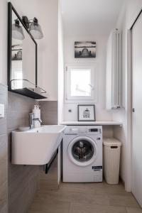 a white bathroom with a washing machine and a sink at Appartamento vicino all'Orto Botanico by Wonderful Italy in Bologna
