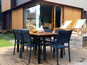 a wooden table and chairs on a deck at Fantástica casa de diseño en Alp in Alp