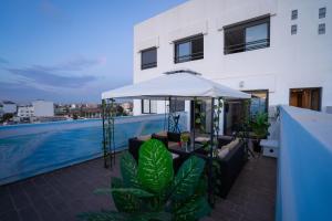 a patio with a white umbrella and a pool at Le Vintage Dead Sea avec Piscine & Rooftop in Casablanca